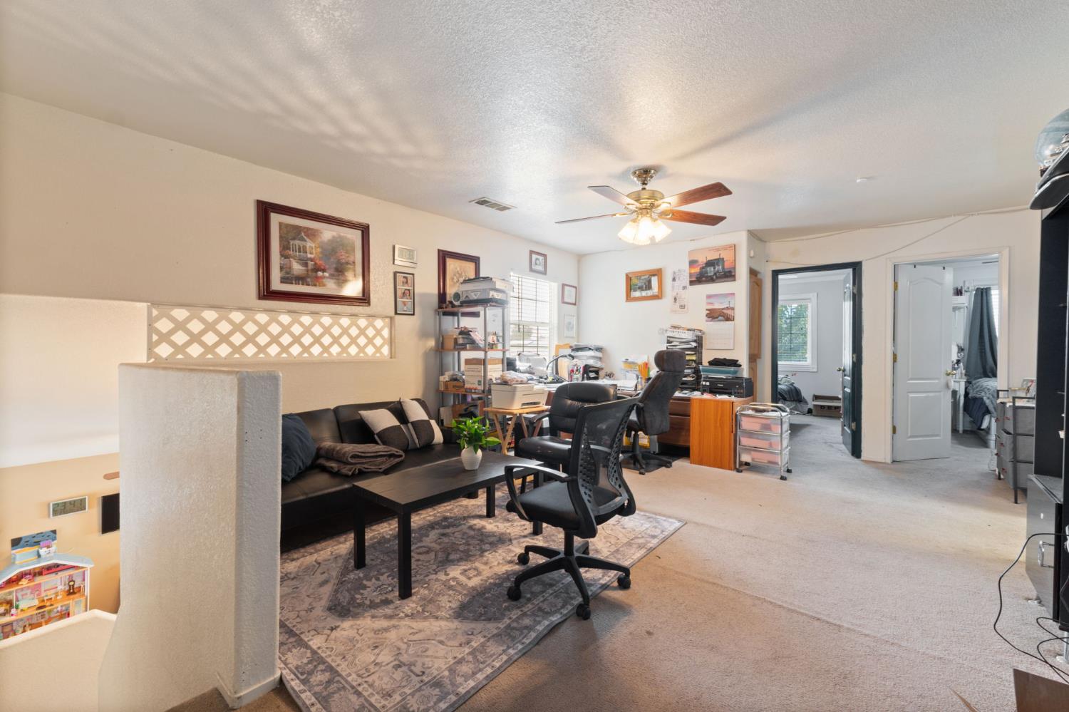 180 Cheney Lane Coalinga, CA 93210 - Photo 19 of 33 a living room with furniture a chandelier fan and a window