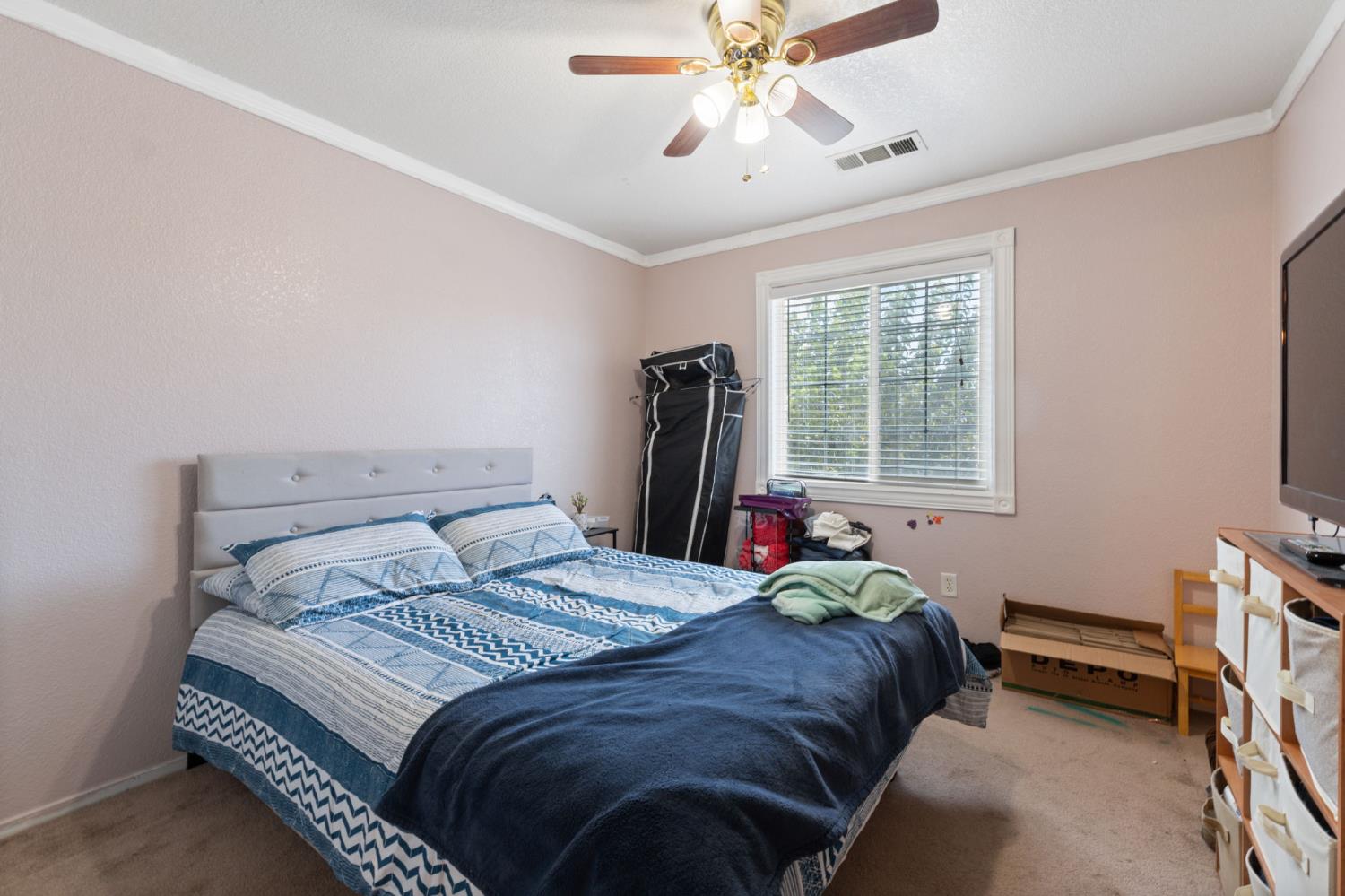180 Cheney Lane Coalinga, CA 93210 - Photo 22 of 33 a bedroom with a bed and a flat tv screen on the dresser