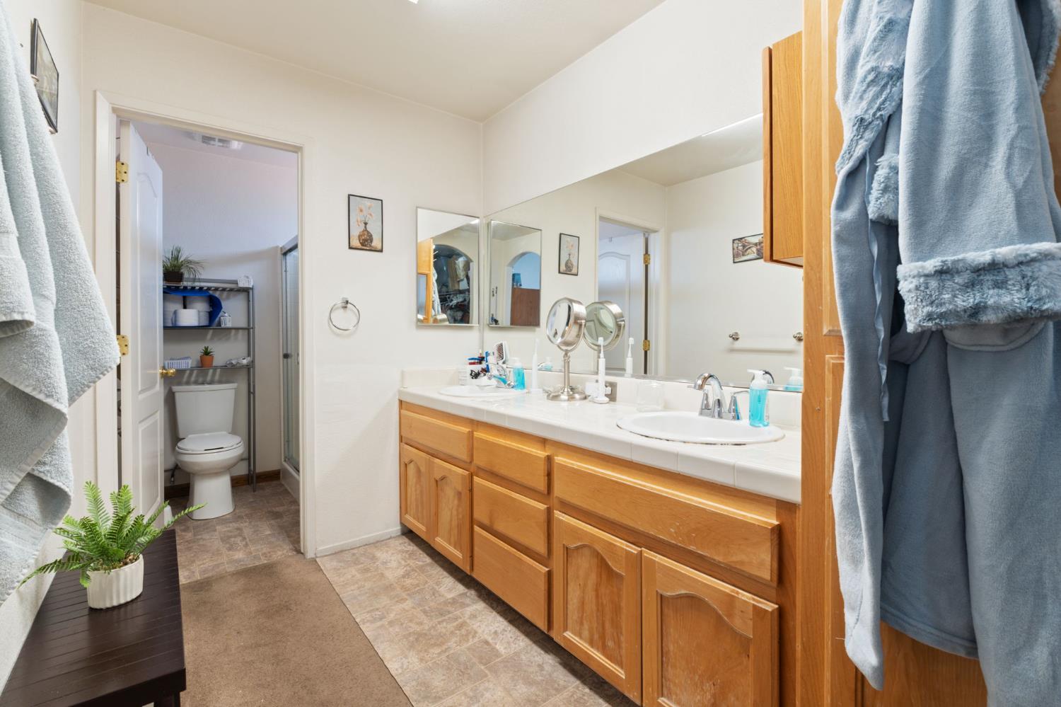 180 Cheney Lane Coalinga, CA 93210 - Photo 25 of 33 a bathroom with a double vanity sink a mirror and a shower