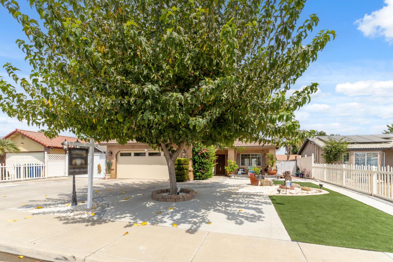 180 Cheney Lane Coalinga, CA 93210 - Photo 4 of 33 a view of a white house with a large tree and plants
