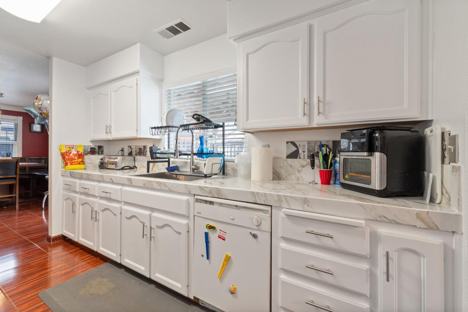 180 Cheney Lane Coalinga, CA 93210 - Photo 6 of 33 a kitchen with white cabinets and white appliances
