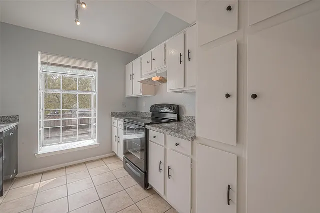 a kitchen with granite countertop white cabinets and a sink