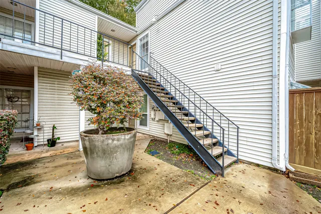 a view of a small house with fountain and potted plants