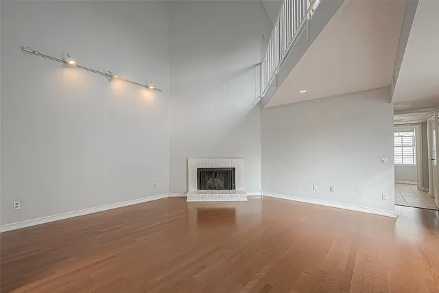 an empty room with wooden floor and fireplace