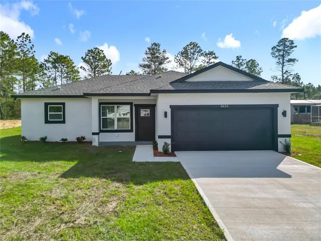a front view of a house with a yard and garage