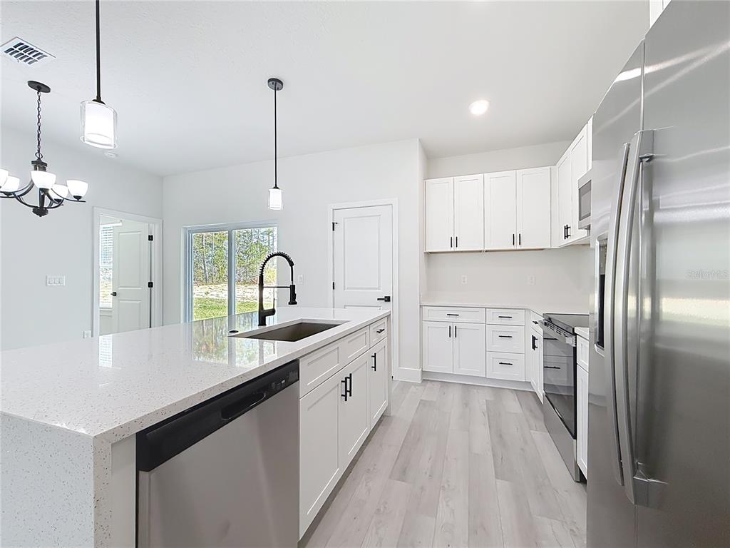 8425 North Legacy Loop Citrus Springs, FL 34433 - Photo 12 of 51 a kitchen with kitchen island a sink appliances and cabinets