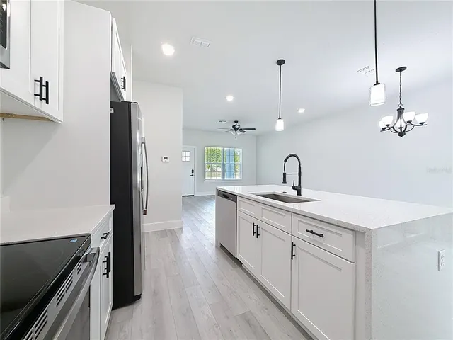 a kitchen with sink refrigerator and stove