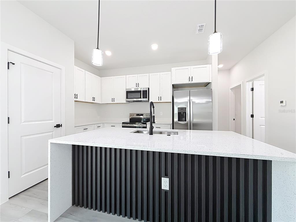 8425 North Legacy Loop Citrus Springs, FL 34433 - Photo 18 of 51 a large kitchen with kitchen island a sink stainless steel appliances and cabinets