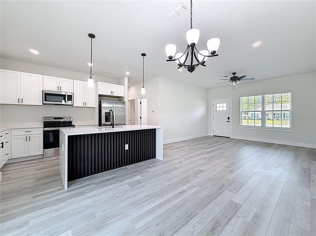 8425 North Legacy Loop Citrus Springs, FL 34433 - Photo 19 of 51 a open kitchen with stainless steel appliances granite countertop wooden floors wooden cabinets a window and a sink