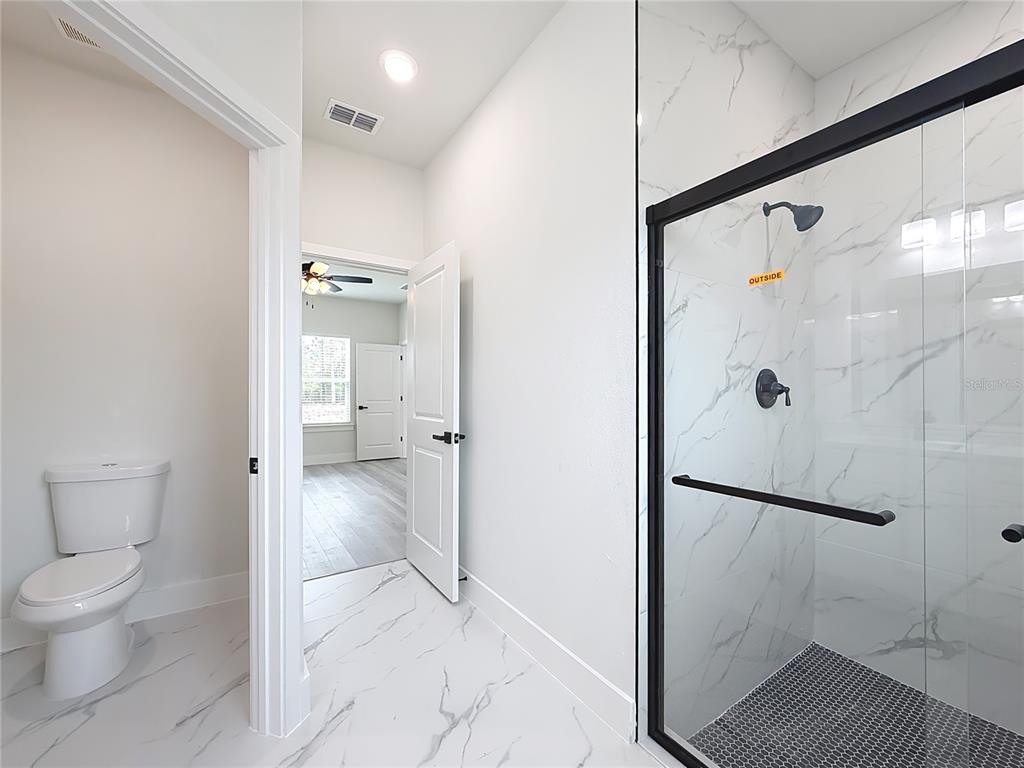 8425 North Legacy Loop Citrus Springs, FL 34433 - Photo 28 of 51 a bathroom with a shower and a toilet