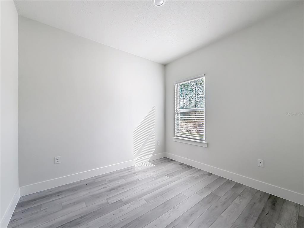 8425 North Legacy Loop Citrus Springs, FL 34433 - Photo 29 of 51 an empty room with wooden floor and window