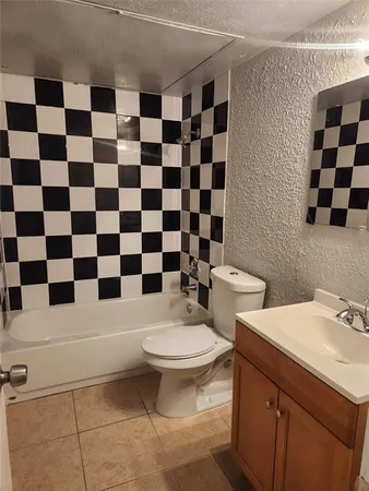 a bathroom with a black and white checkered floor