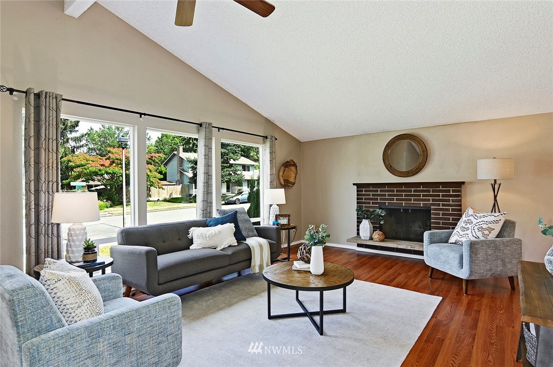 795 South 27th Street Renton, WA 98055 - Photo 2 of 14 a living room with furniture a fireplace and a floor to ceiling window