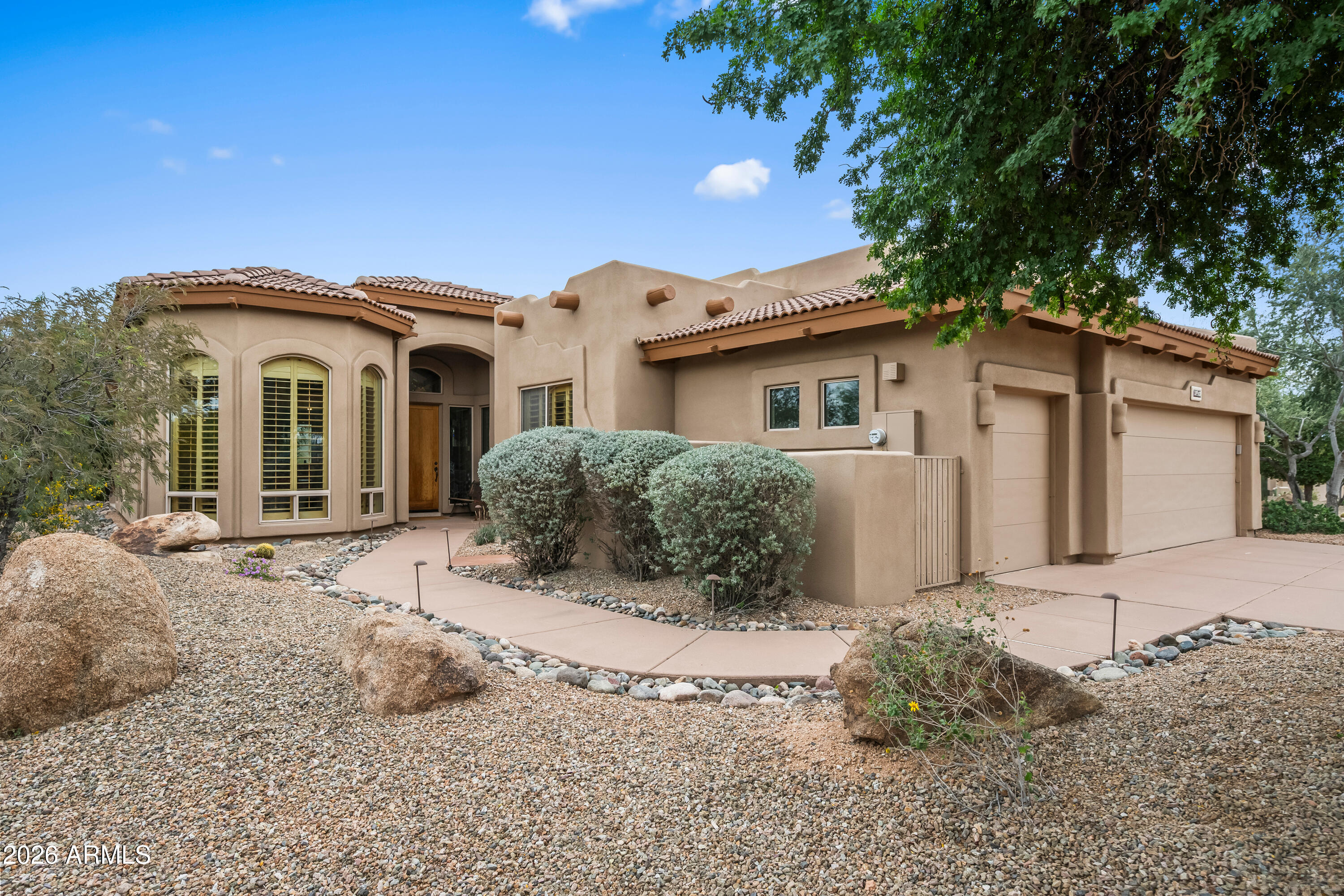 a front view of a house with a garden and yard