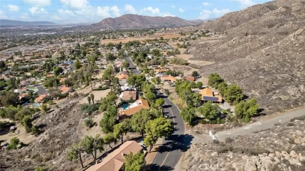an aerial view of residential houses with outdoor space and trees