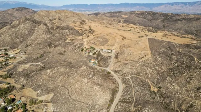 a view of a dry yard with mountains in the background