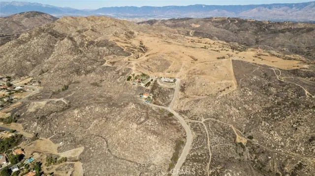a view of a dry yard with mountains in the background