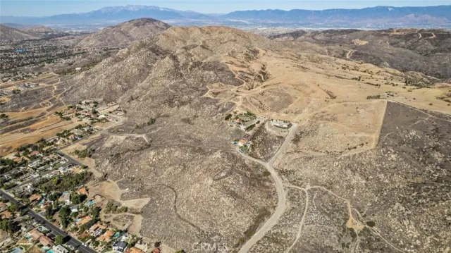 a view of a dry yard with mountains in the background