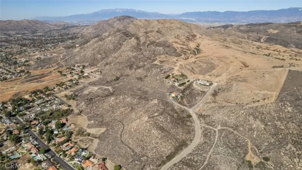 a view of a dry yard with mountains in the background