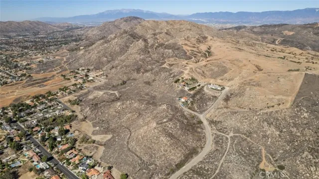 a view of a dry yard with mountains in the background