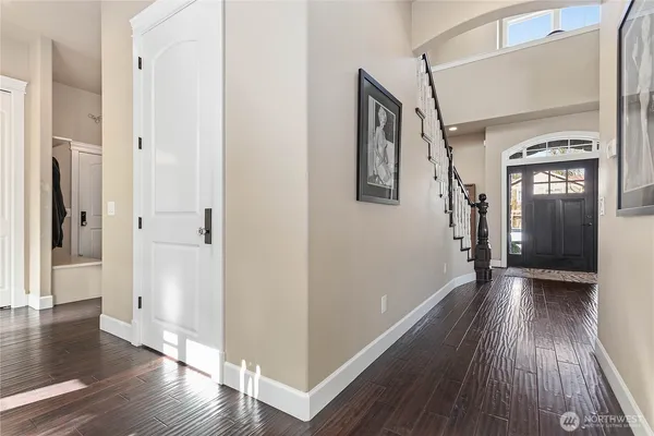a view of a hallway with wooden floor and stairs