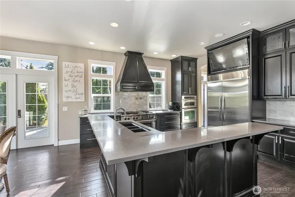 a kitchen with stainless steel appliances a dining table chairs and wooden floor