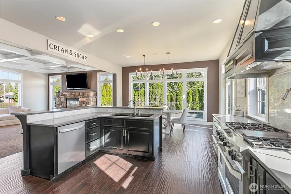 a kitchen with stainless steel appliances granite countertop a stove and a wooden floors
