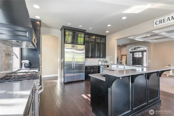 a kitchen with stainless steel appliances granite countertop a sink a stove and a refrigerator