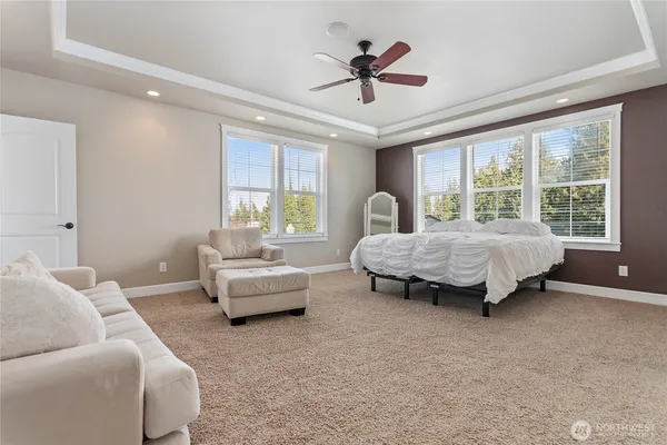 a spacious bedroom with a bed and glass window