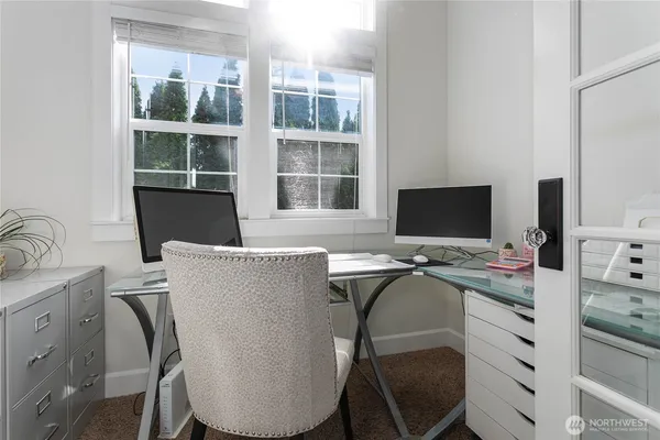 a view of a workspace with furniture and a window