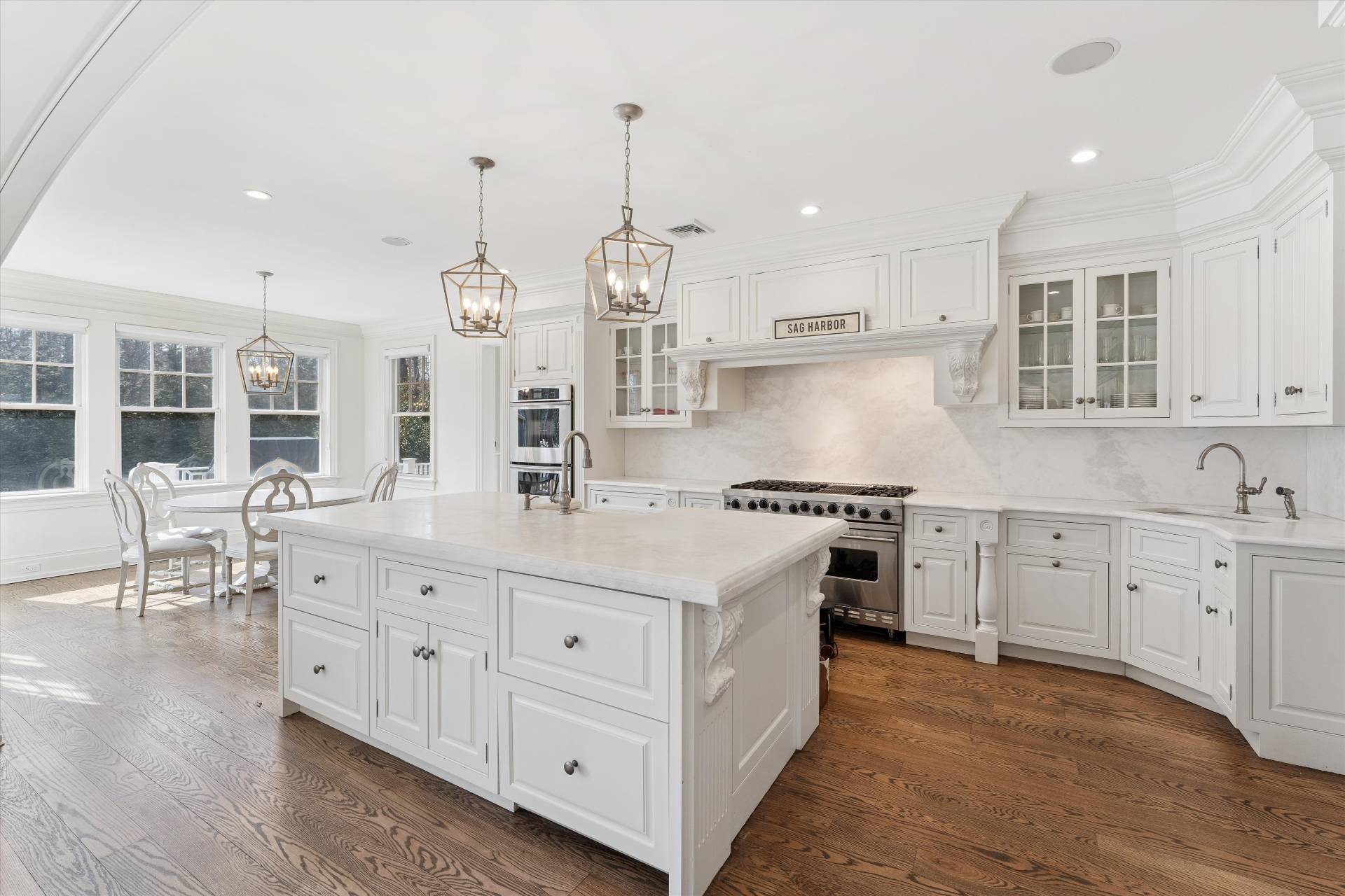 154 Northside Drive Sag Harbor, NY 11963 - Photo 6 of 21 a large kitchen with kitchen island a stove a sink a center island and wooden floor