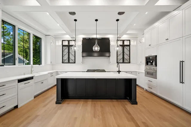 a large kitchen with stainless steel appliances a sink and cabinets