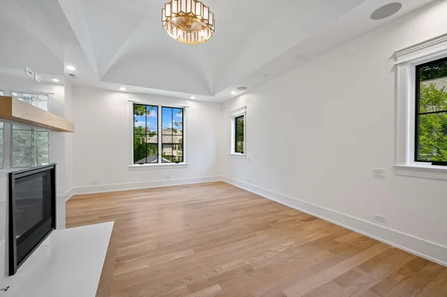 an empty room with windows and fireplace