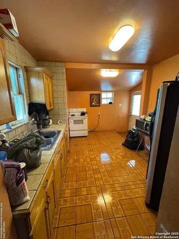 a kitchen with a sink a window and cabinets