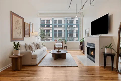 a living room with furniture a fireplace and a flat screen tv