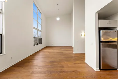 a living room with stainless steel appliances kitchen island granite countertop a stove a sink a dining table and chairs with wooden floor