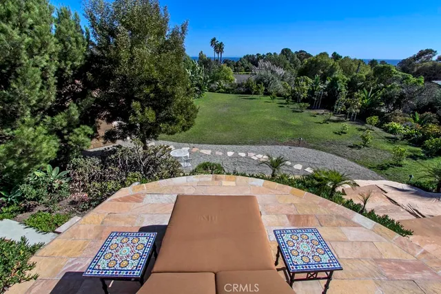 a view of backyard with table and chairs and potted plants