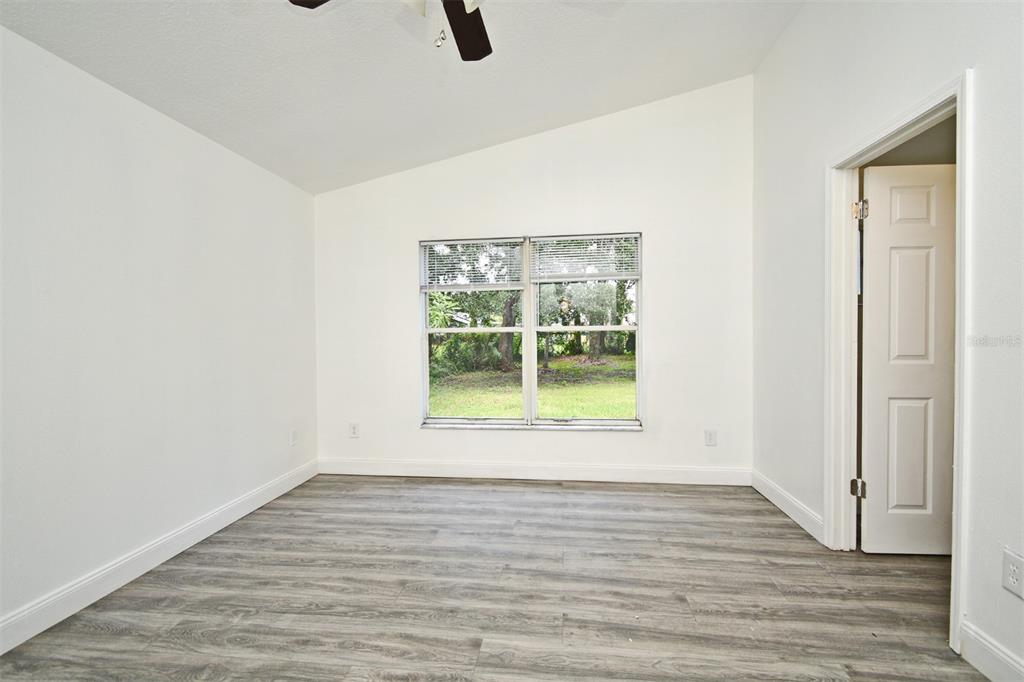 1502 West 16th Street Sanford, FL 32771 - Photo 8 of 12 a view of an empty room with wooden floor and a window