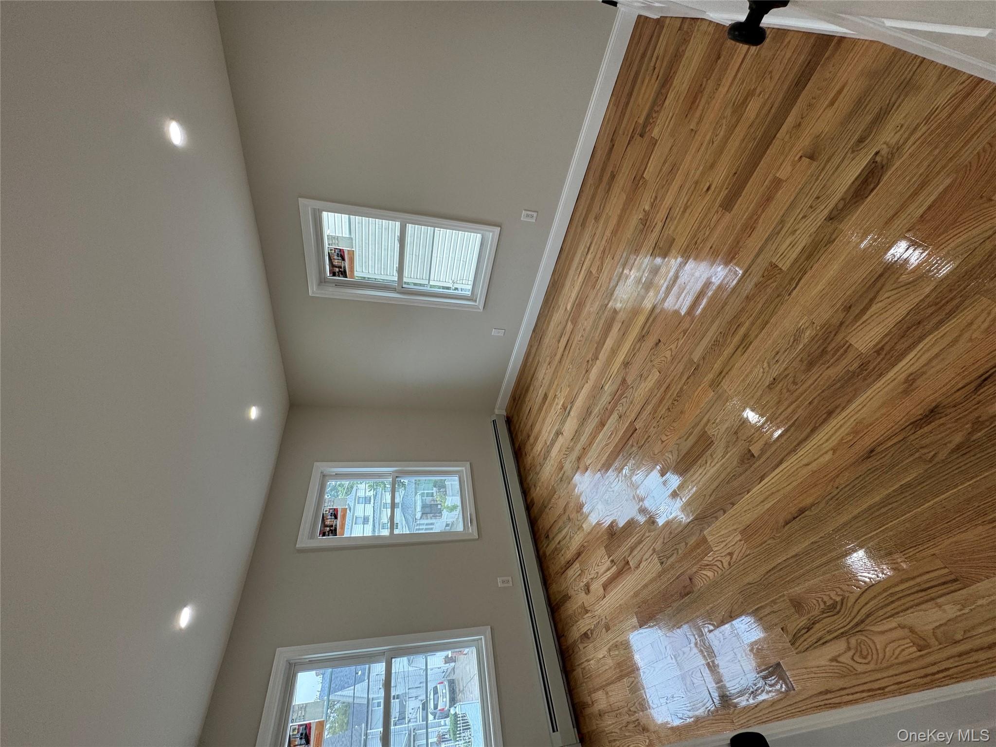 194-45 Murdock Avenue Queens, NY 11412 - Photo 11 of 23 a view of empty room with wooden floor and fan