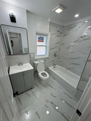 a bathroom with a double vanity sink a toilet and mirror