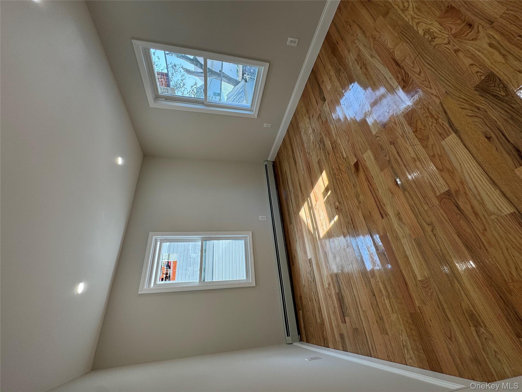 194-45 Murdock Avenue Queens, NY 11412 - Photo 16 of 23 a view of empty room with window and wooden floor