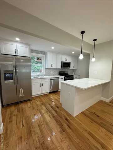 a large kitchen with cabinets and wooden floor