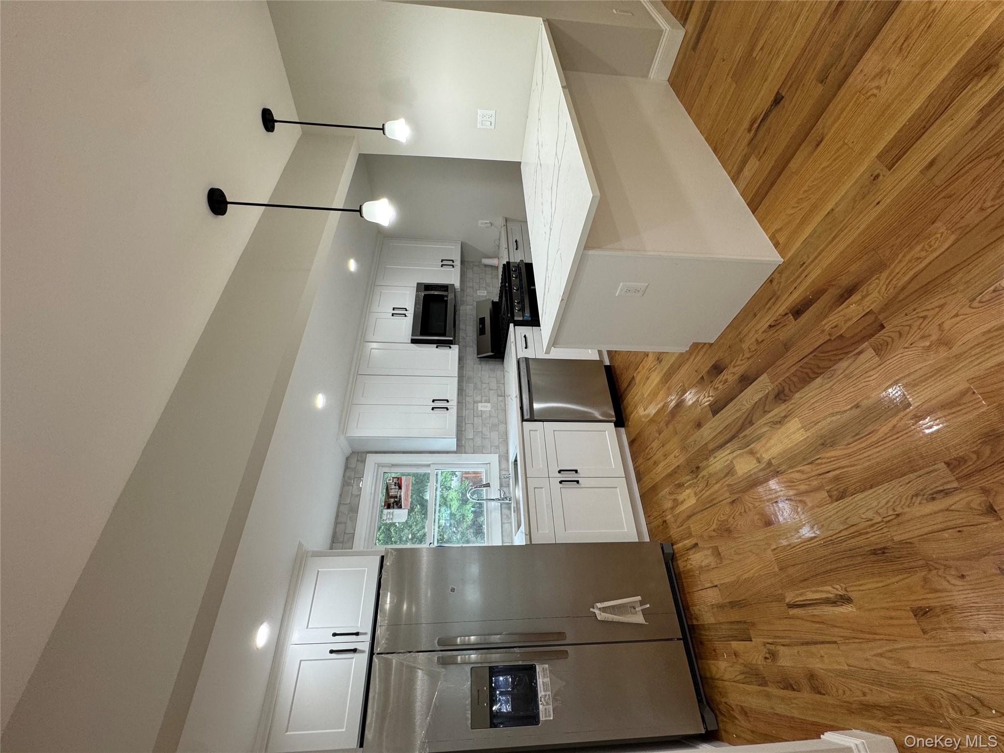 194-45 Murdock Avenue Queens, NY 11412 - Photo 6 of 23 a large kitchen with cabinets and wooden floor