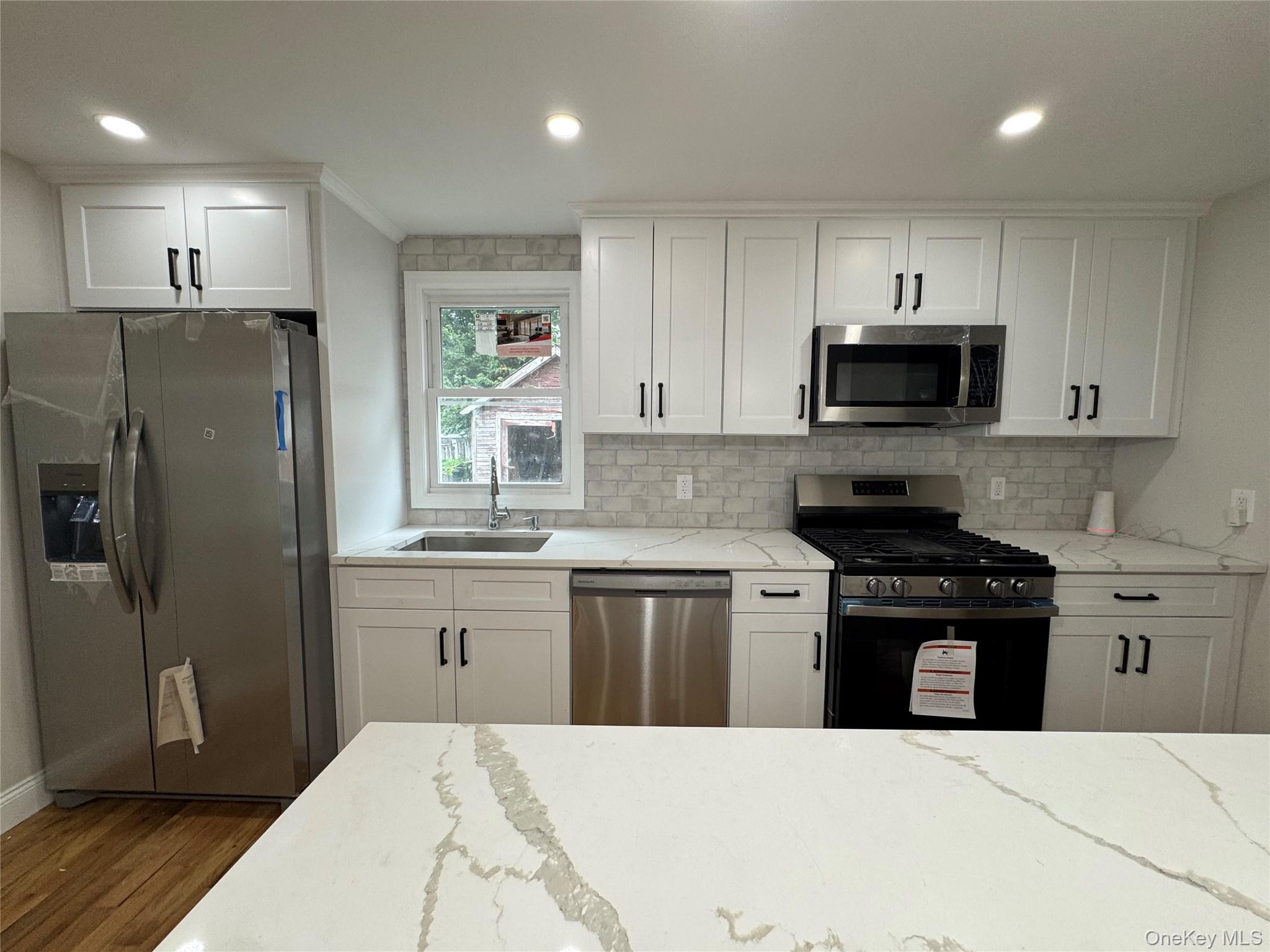 194-45 Murdock Avenue Queens, NY 11412 - Photo 7 of 23 a kitchen with stainless steel appliances a refrigerator stove microwave and sink