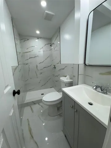 a bathroom with a sink a toilet and mirror