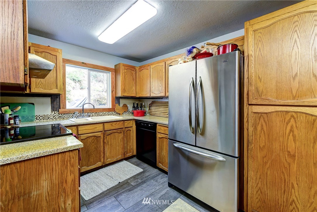 3625 Newberg Road Snohomish, WA 98290 - Photo 9 of 25 a kitchen with stainless steel appliances granite countertop a refrigerator and a sink