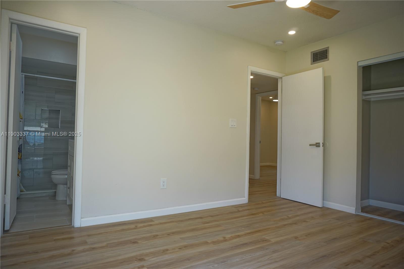 971 Fulton Lane Northeast Palm Bay, FL 32905 - Photo 14 of 29 a view of an empty room with wooden floor and a bathroom