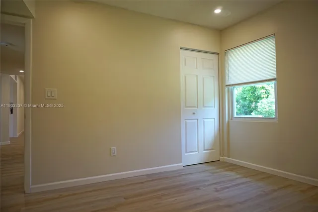 an empty room with wooden floor and a window