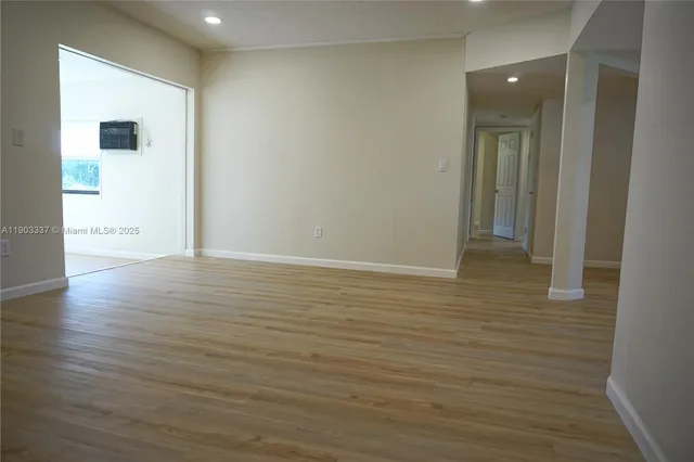a view of an empty room with wooden floor