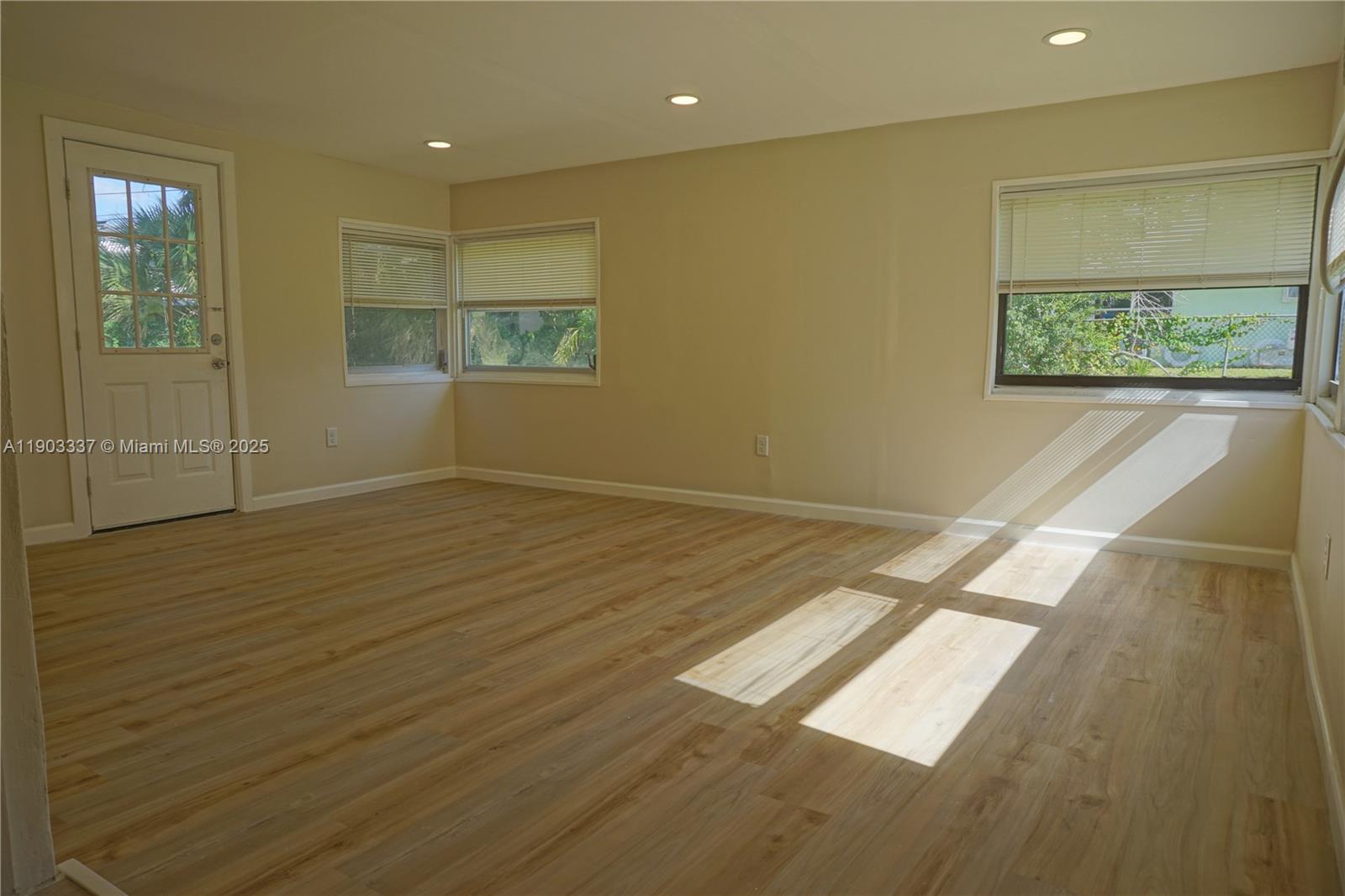 971 Fulton Lane Northeast Palm Bay, FL 32905 - Photo 19 of 29 an empty room with wooden floor and windows